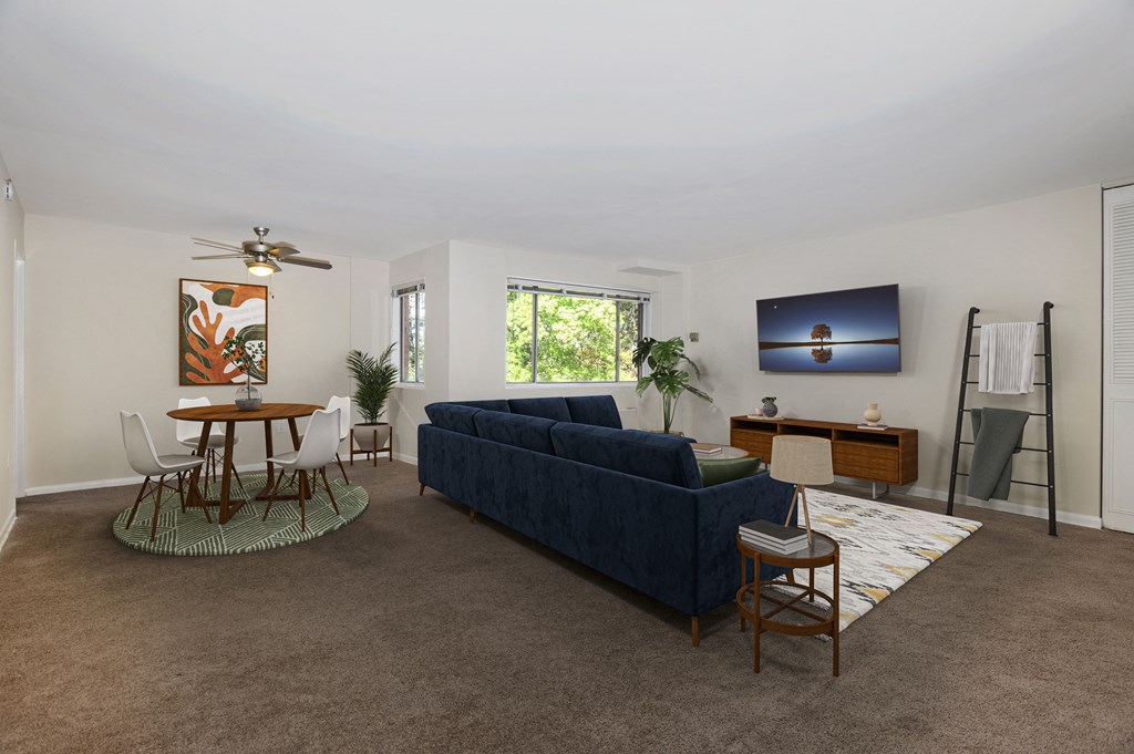 a living room with a blue couch and a table and chairs