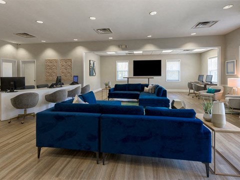 a large living room with blue couches and a television