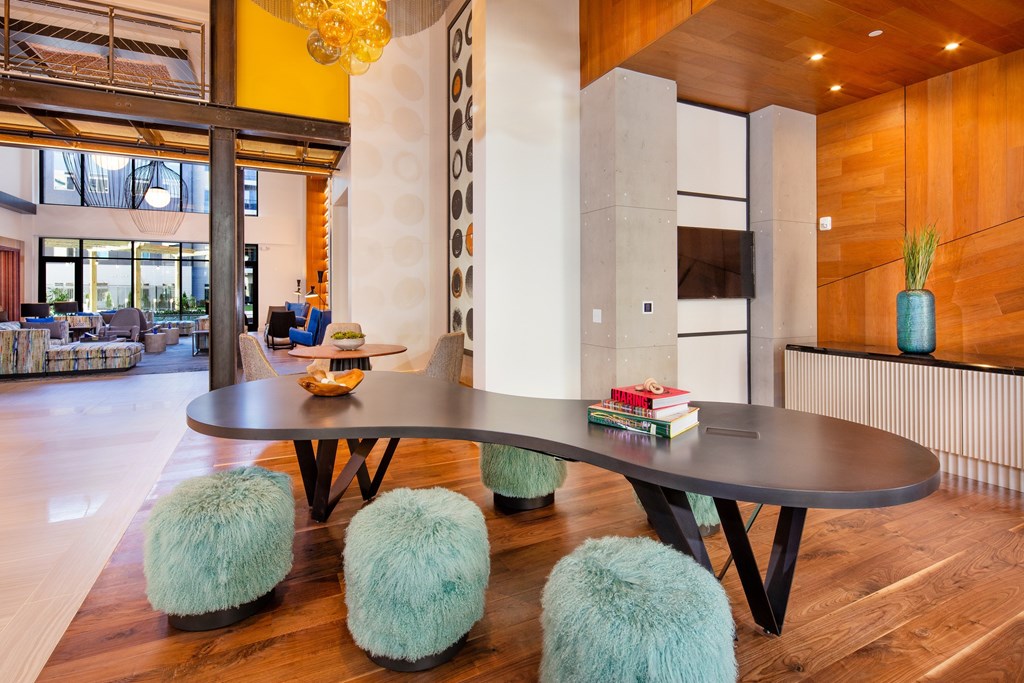 A modern dining room with a round table and blue pouf.