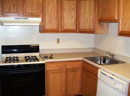 A kitchen with wooden cabinets and a black stove top oven.