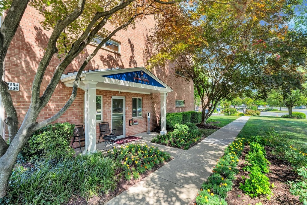 a brick building with a blue awning and a sidewalk in front of it