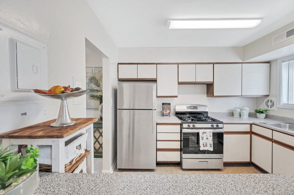 a kitchen with white cabinets and stainless steel appliances