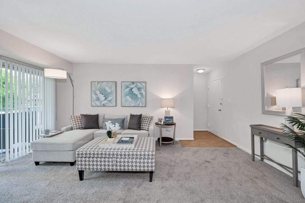 a living room with grey carpet and white walls