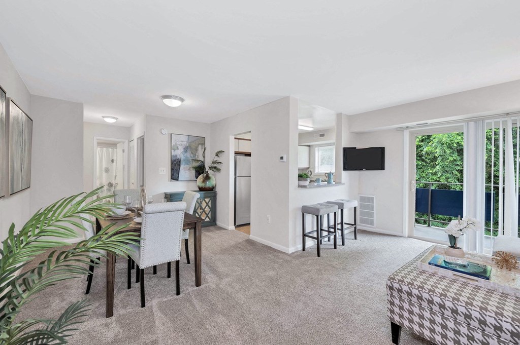 a living room and dining room with a table and chairs