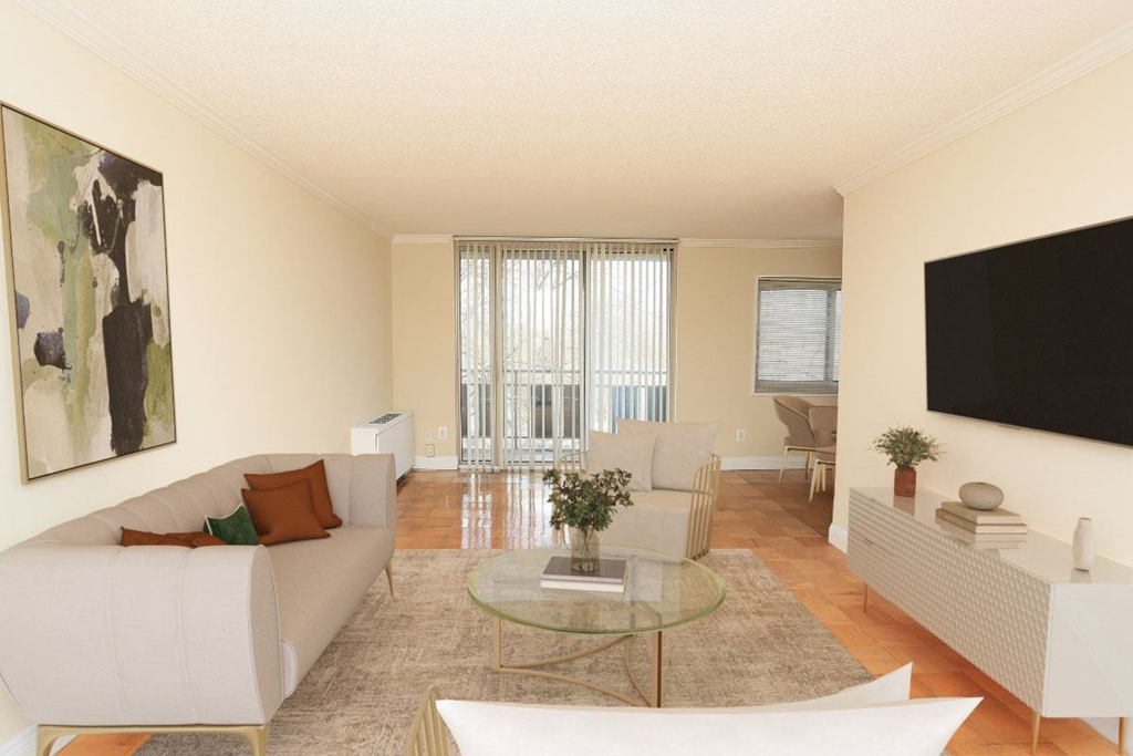 A living room with a white couch and a glass coffee table.