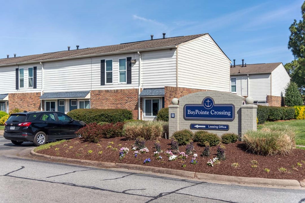 a building with a sign and a car parked in front of it
