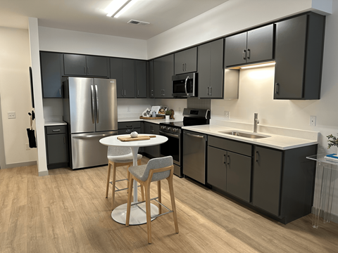 A kitchen with a table and chairs in the middle of it.