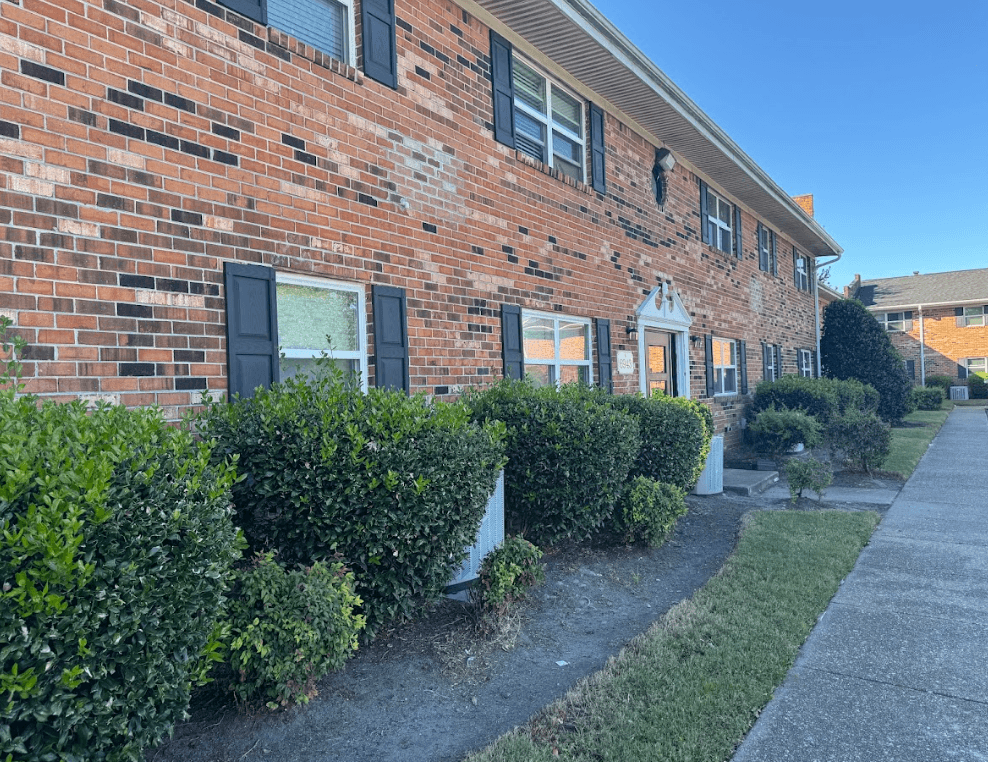 A red brick house with a white door and windows.