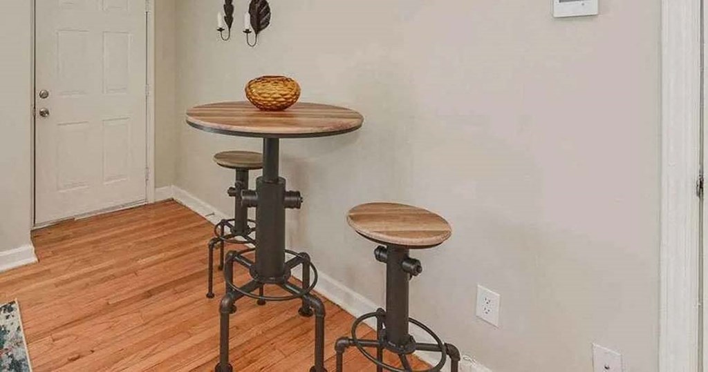 a table and two stools in the corner of a room