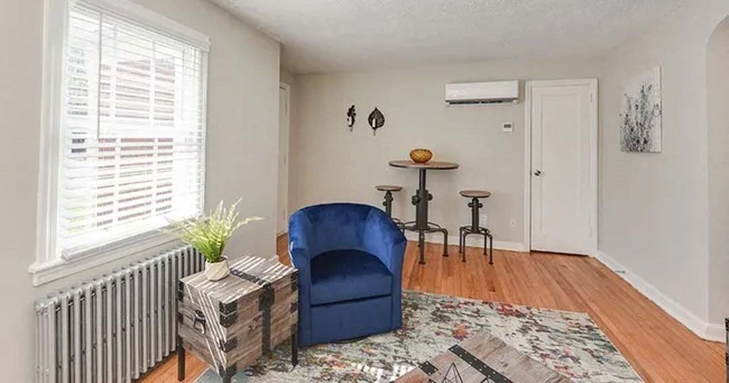 a living room with a blue chair and a table
