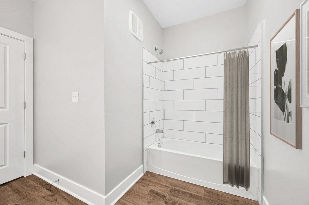 a white bathroom with a tub and a curtain