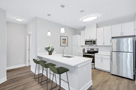 a kitchen with a large island and a stainless steel refrigerator