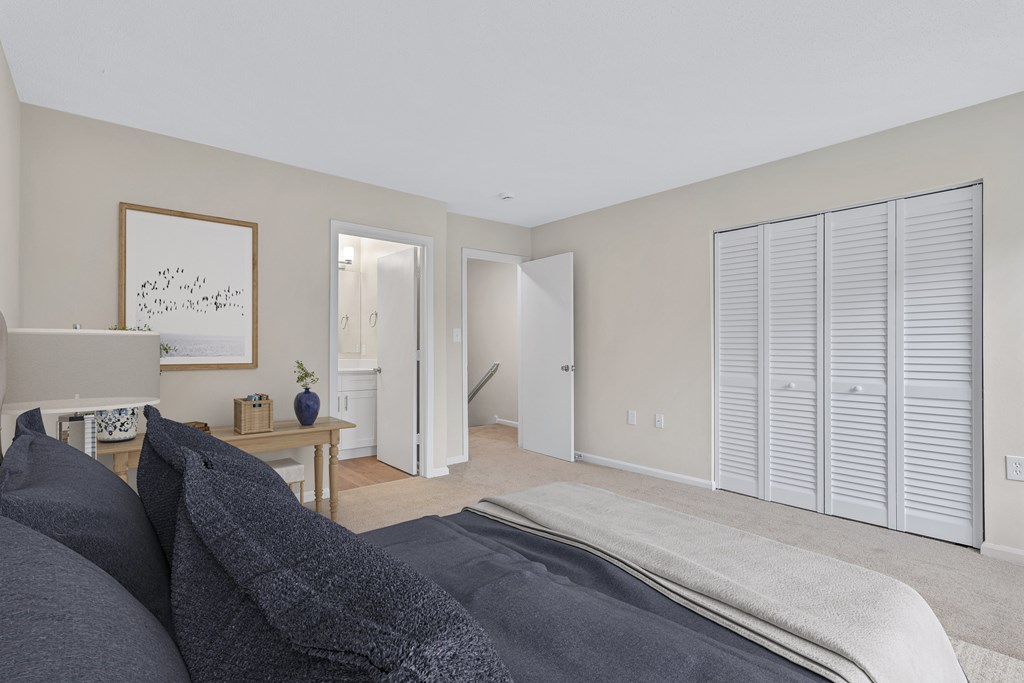 A bedroom with a large bed and a painting on the wall.