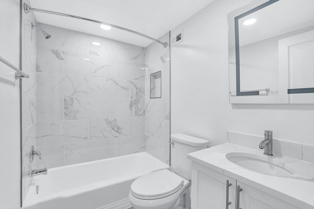 a white bathroom with a shower toilet and sink