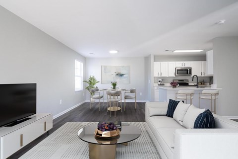 A modern living room with a white sofa and a glass coffee table.