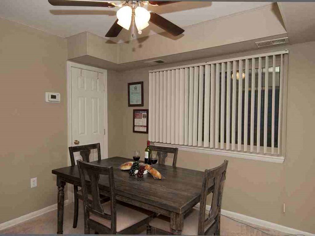 a dining room with a table and chairs and a ceiling fan