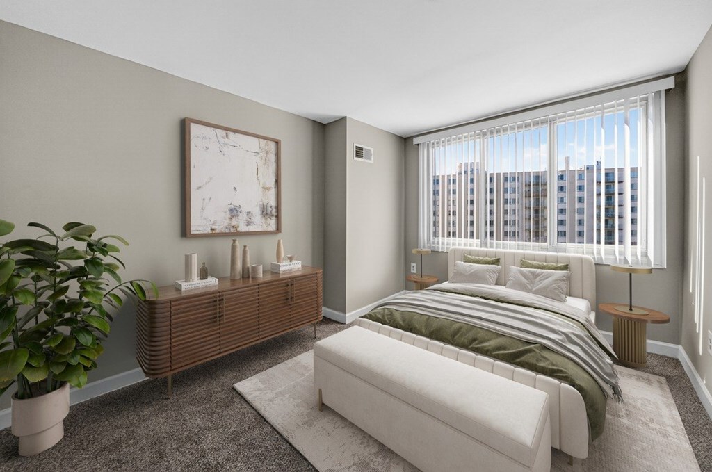 A bedroom with a large bed, a wooden cabinet, and a potted plant.