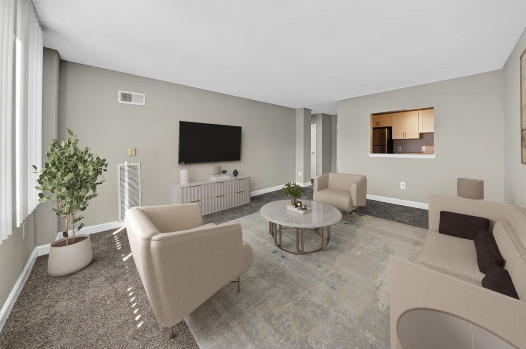 A living room with a television, two couches, and a potted plant.