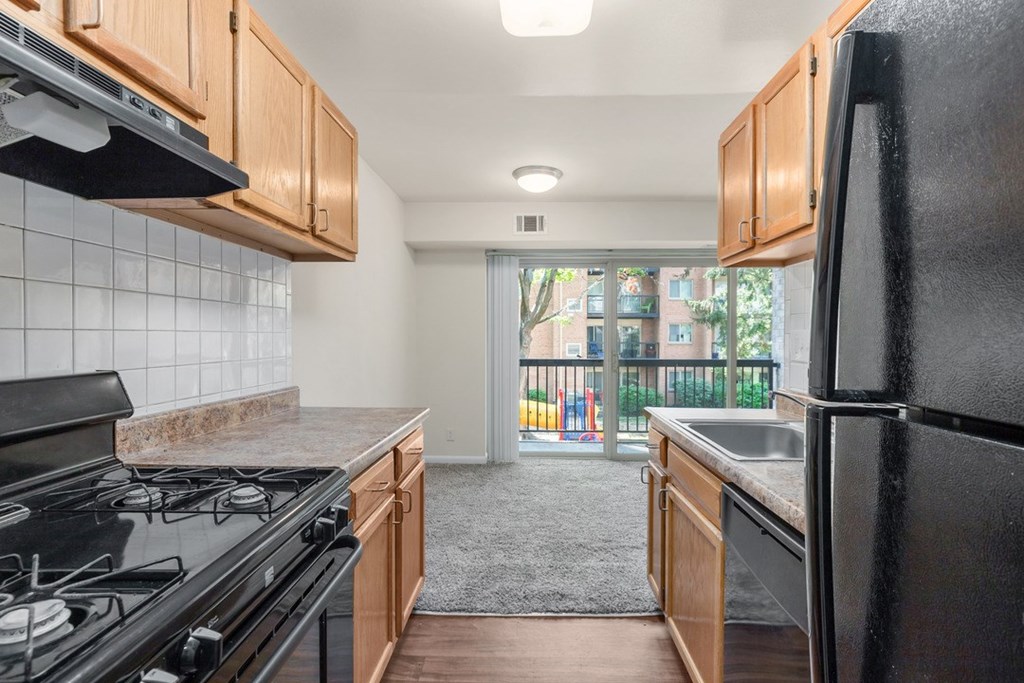 A kitchen with black appliances and wooden cabinets.