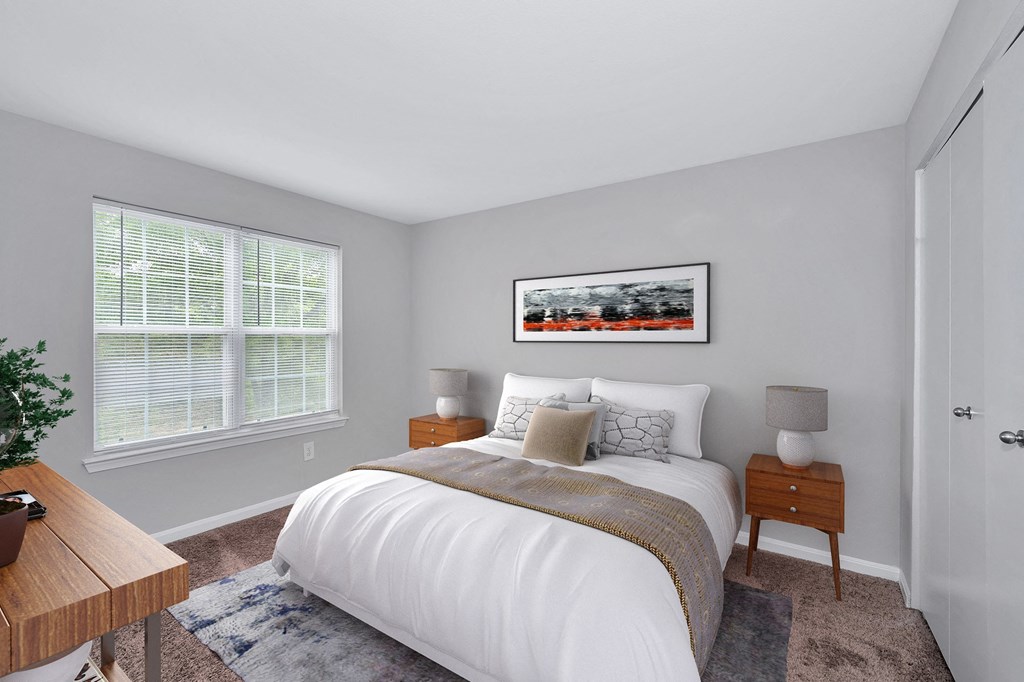 An apartment bedroom with bright window with blinds; showing bed and with night stands on both sides.