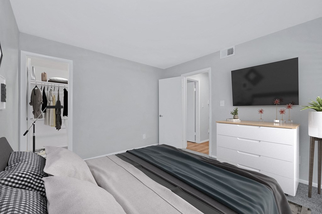 a bedroom with a large bed and a dresser with a television on the wall