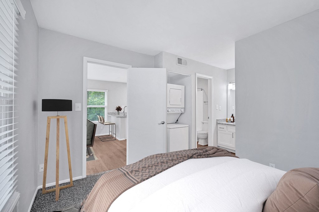 a bedroom with a large bed and a bathroom in the background