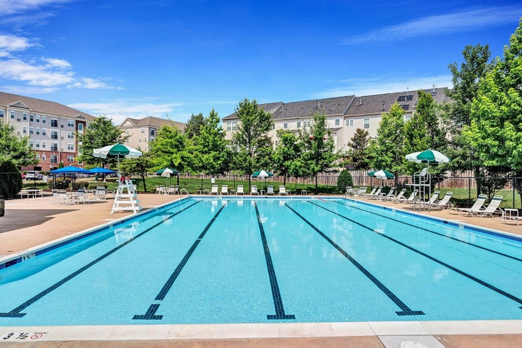 a swimming pool with trees and a building in the background