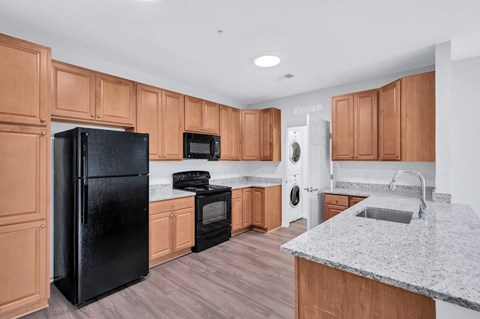 a kitchen with wooden cabinets and a black refrigerator