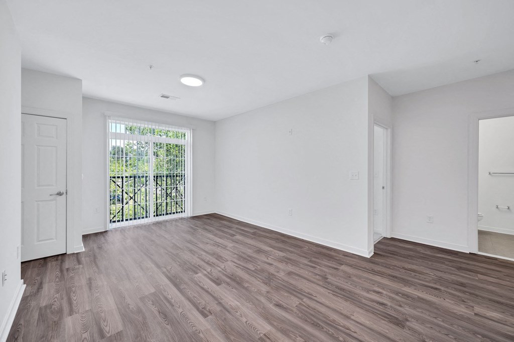 an empty living room with white walls and wood flooring