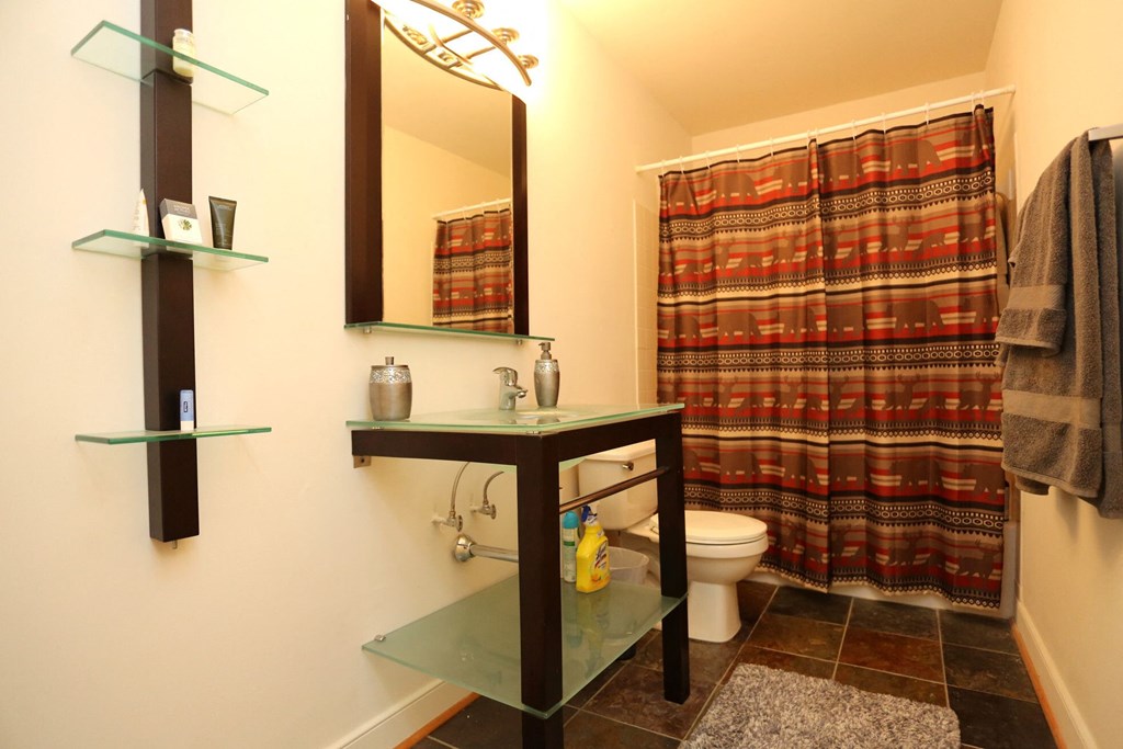 a bathroom with a shower and a toilet and a sink