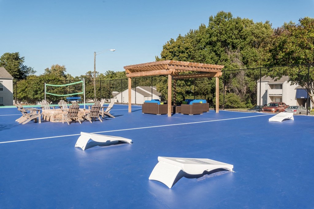 a basketball court with a pergola and lounge chairs