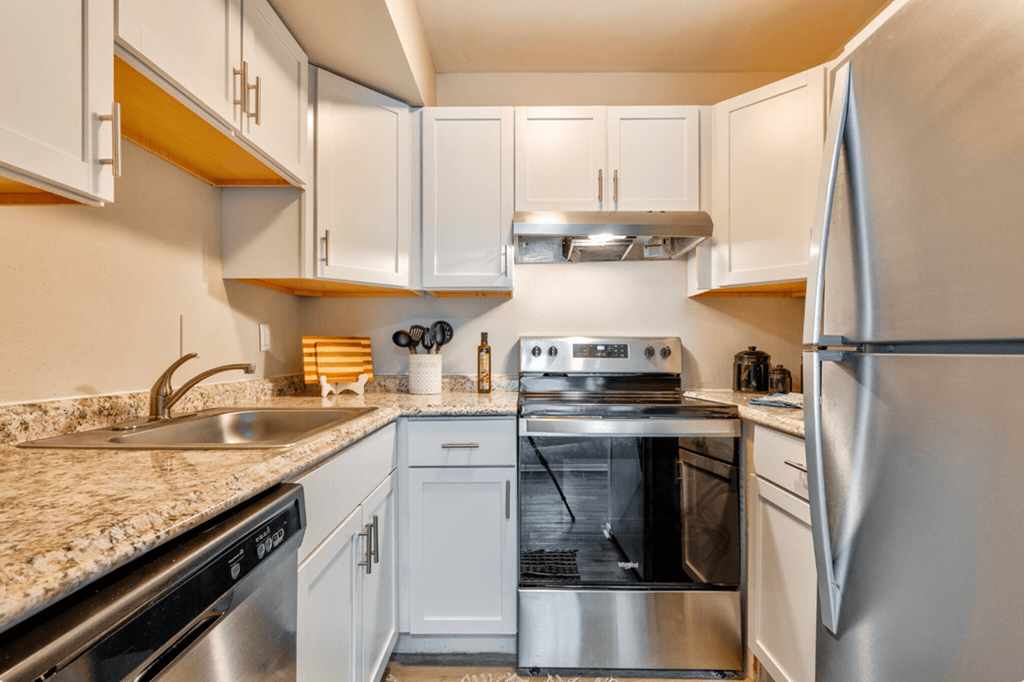 a kitchen with white cabinets and stainless steel appliances and granite counter tops