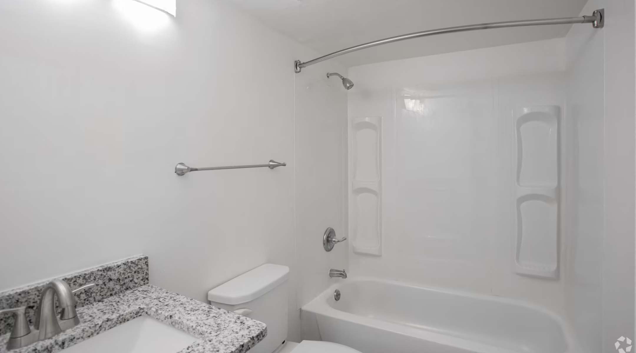 a white bathroom with a tub and a sink and a toilet