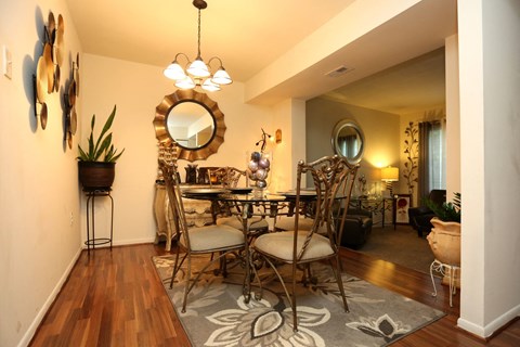 a dining room with a table and chairs and a mirror on the wall
