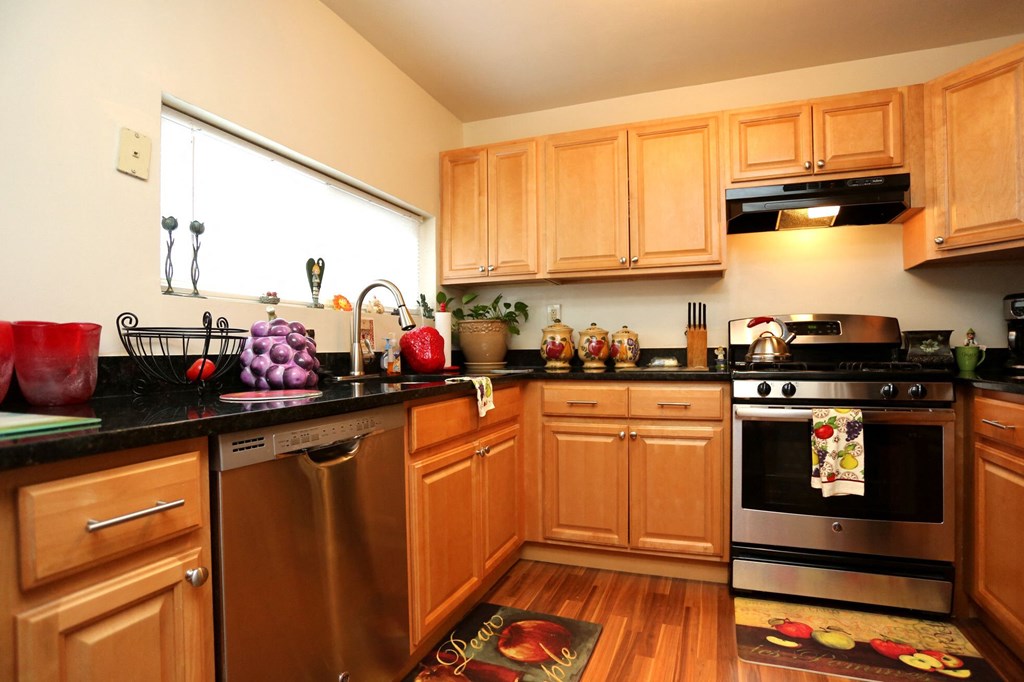 a kitchen with wooden cabinets and stainless steel appliances
