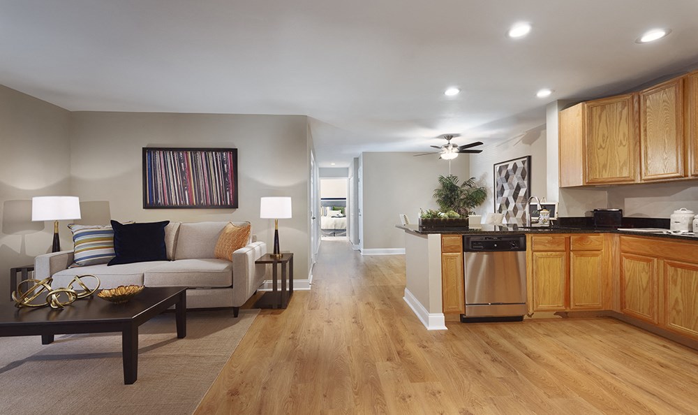 A modern living room with a white couch and a wooden floor.