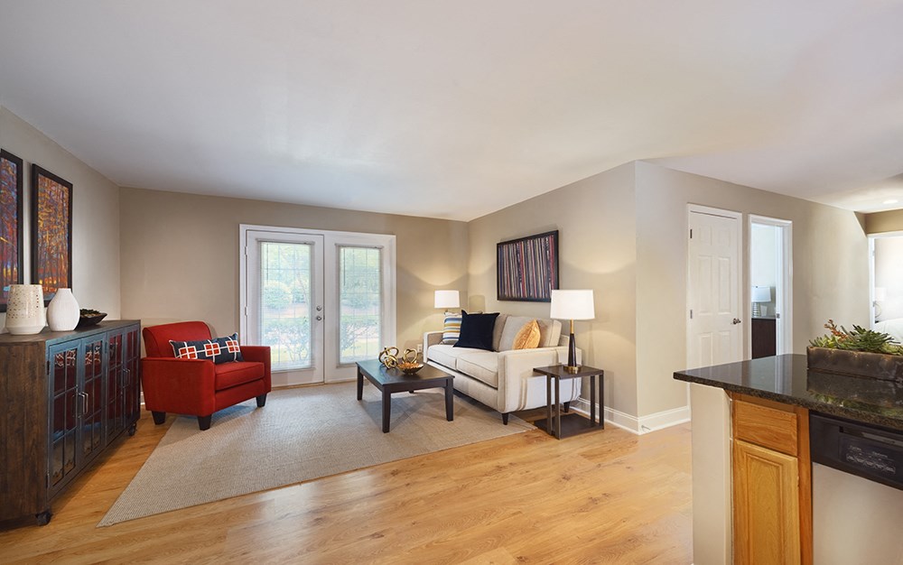 A living room with a red chair and a white couch.