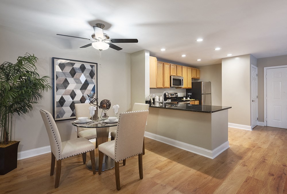 A modern kitchen with a dining table set for two.