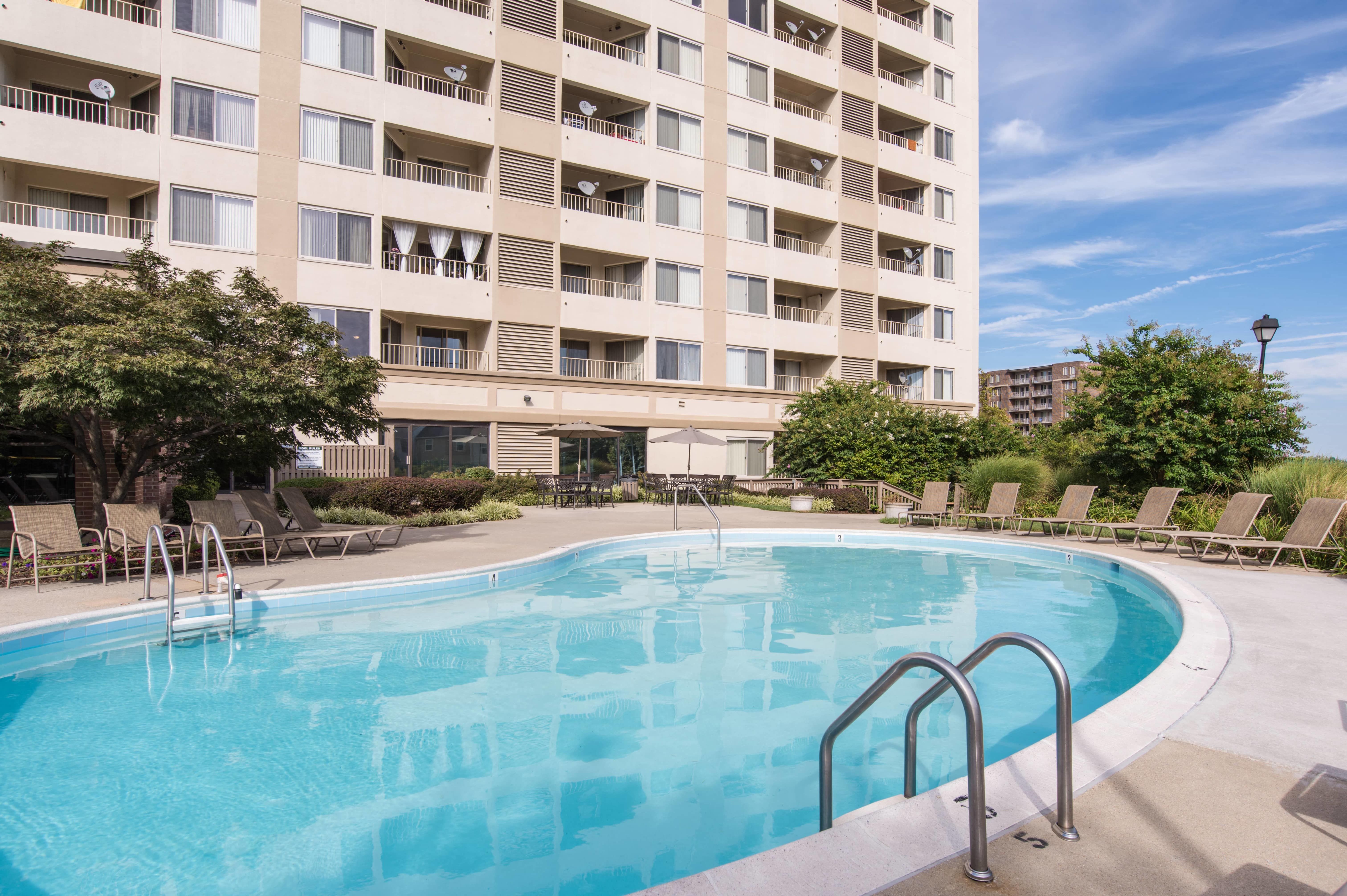 a large swimming pool in front of a hotel