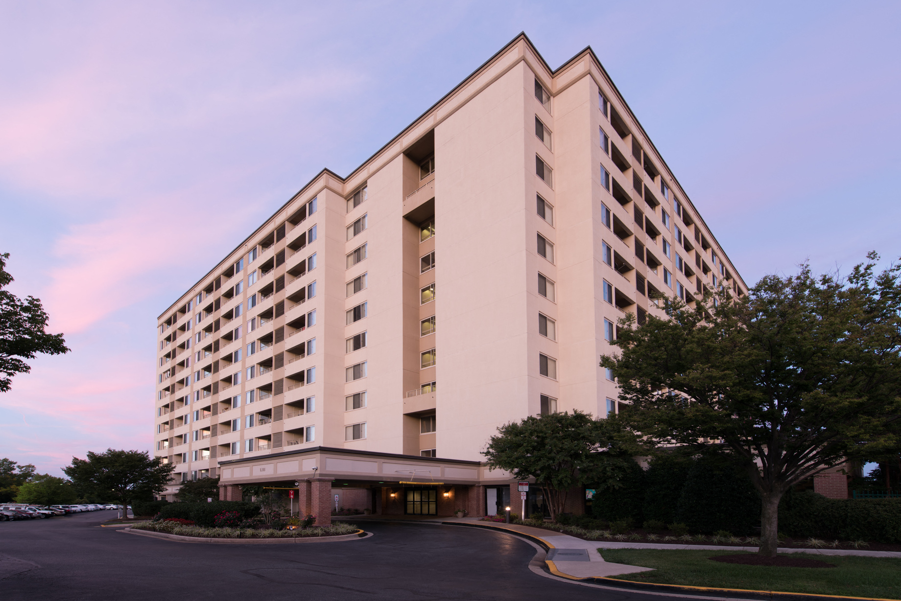 a large hotel building with trees in front of it