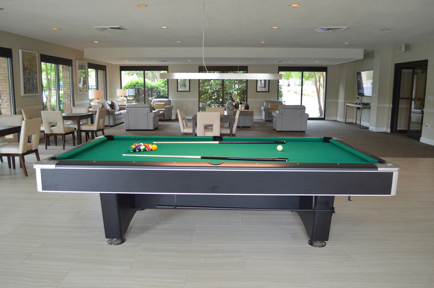 a pool table in a living room with tables and chairs
