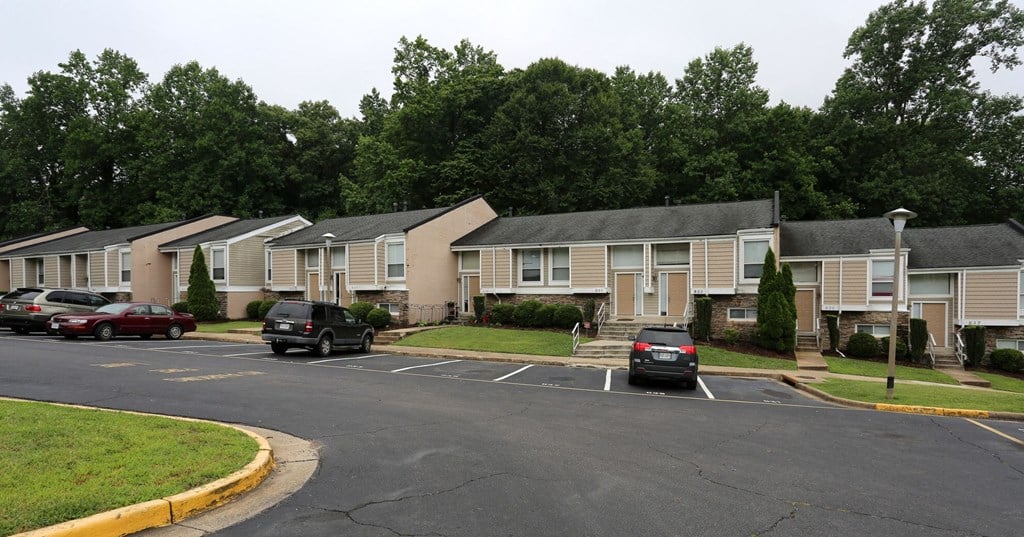 a row of houses with cars parked in a parking lot