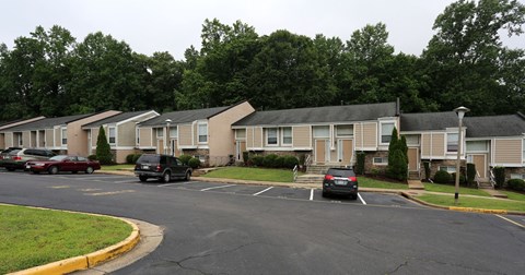 a row of houses with cars parked in a parking lot