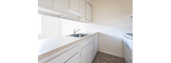 A kitchen with white cabinets and a sink.