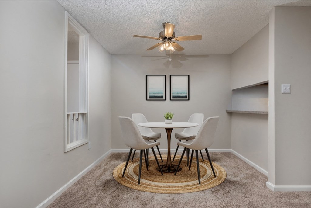 a dining room with a table and chairs and a ceiling fan