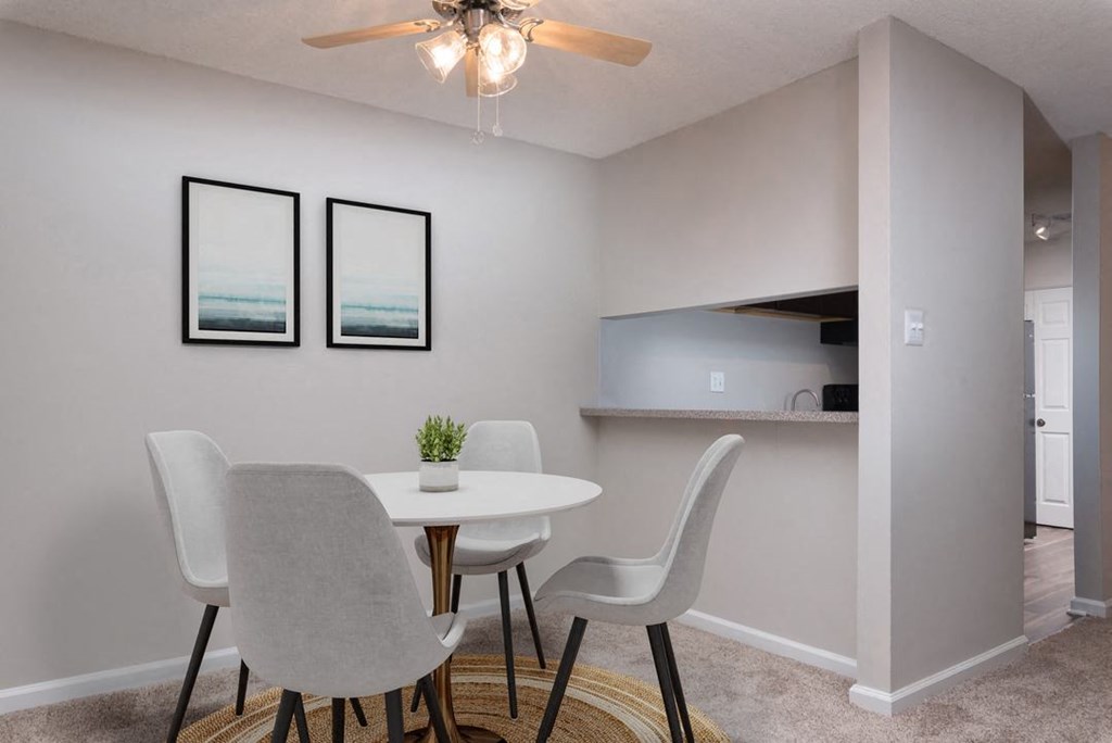 a dining area with a table and chairs and a ceiling fan