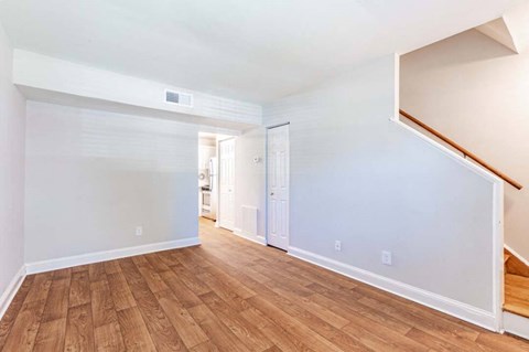 the living room and dining room of an empty house with wood floors