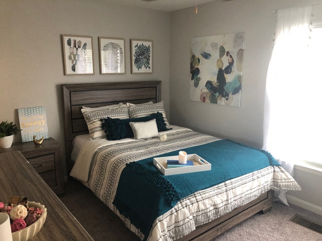 a bedroom with a bed and pictures on the wall