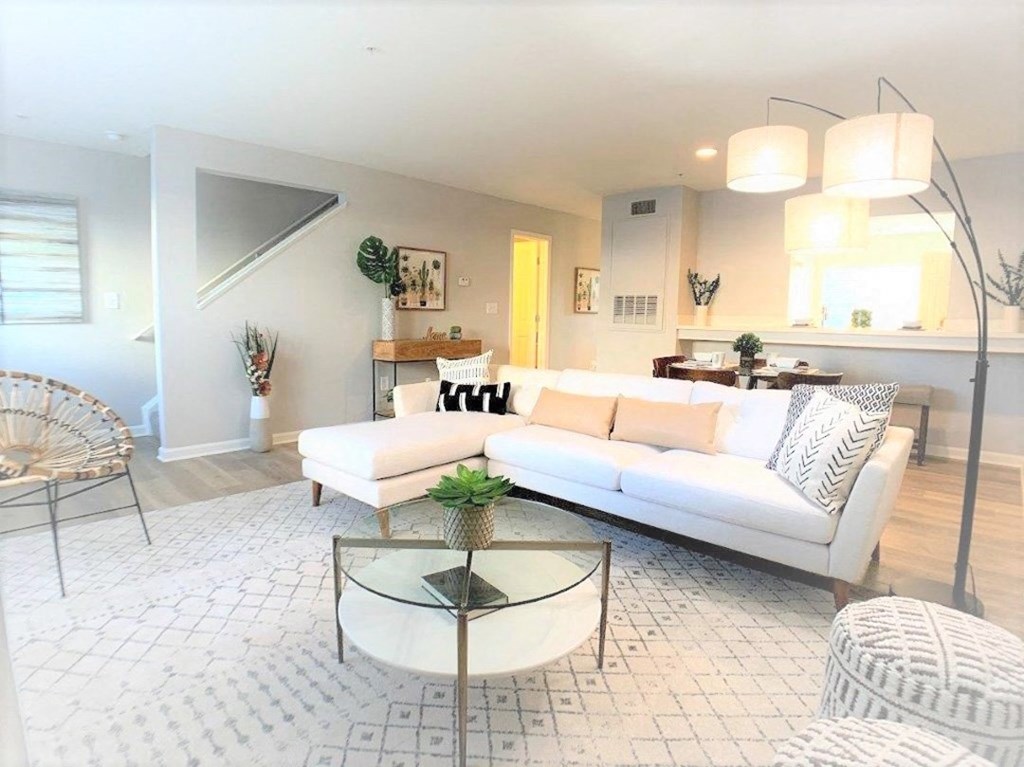 a living room with a white couch and a glass table