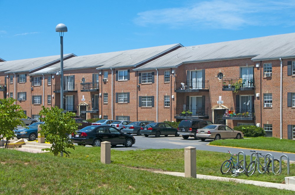 a large brick building with cars parked in a parking lot